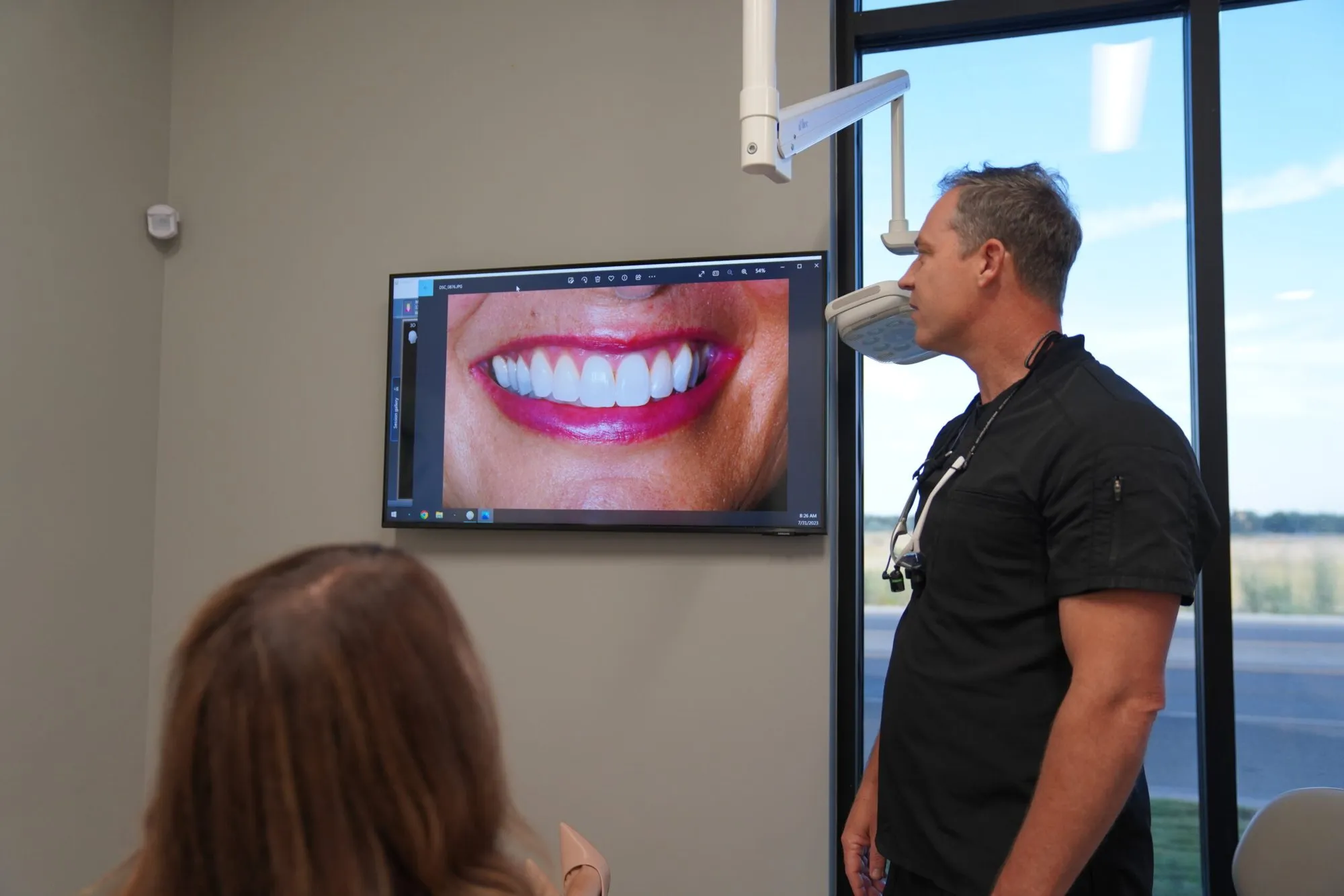 A patient viewing a smile image on the treatment room screen